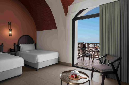 拉斯阿尔卡麦阿尔卡麦小湾罗塔娜度假村的一间带两张床的卧室和一个阳台。