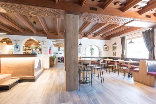 博萨迪法萨Hotel Crepei的餐厅设有木制天花板和桌椅