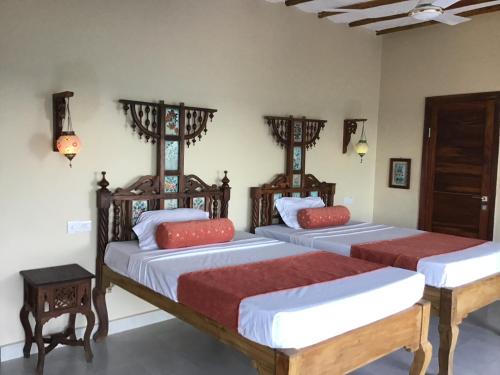 普瓦尼梅查恩加尼Nakupenda Malaika Flat的一间卧室配有两张带红色枕头的床
