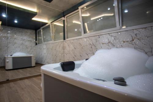 InđijaMonogramlux的浴室配有带泡沫的浴缸。
