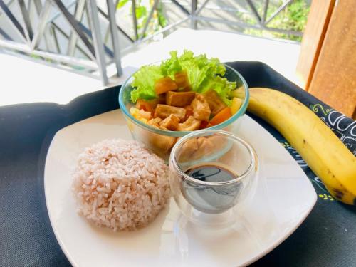 伊洛伊洛Balai Lawaan Cozy Homestay的盘子,盘子上放着米饭,一碗沙拉和香蕉