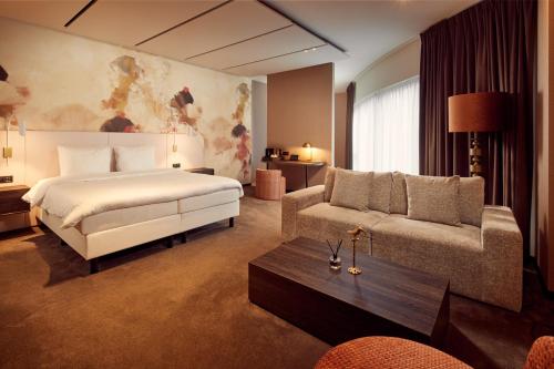 根特Van der Valk Hotel Gent的酒店客房,配有床和沙发
