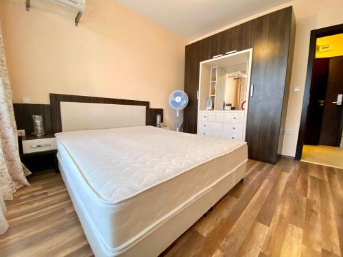 普里莫尔斯科Green Paradise Deluxe Apartments的卧室设有一张白色大床和木地板