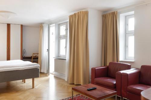 隆德隆德阿姆斯主教酒店的一间卧室配有一张床、一张沙发和一把椅子