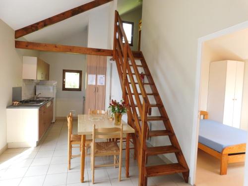 Saint-Denis-du-MaineVillage de Gîtes de La Chesnaie的房屋内的厨房和用餐室,配有木楼梯