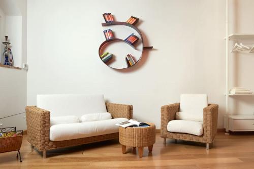 雷卡纳蒂Appartamentino IL NIDO vista mare的客厅配有两把椅子、一张沙发和镜子
