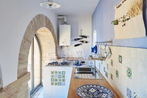 雷卡纳蒂Appartamentino IL NIDO vista mare的厨房配有水槽和拱形窗户