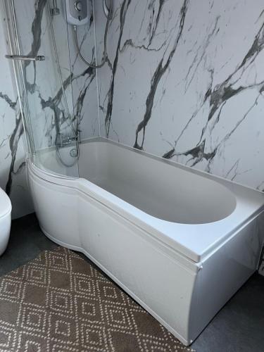 爱丁堡4 bed bungalow near Airport的浴室内设有一个白色浴缸