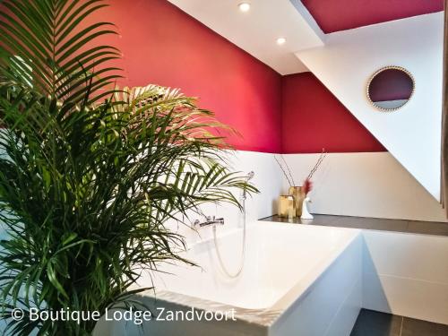 赞德沃特Boutique Lodge Zandvoort的带淋浴和植物的浴室