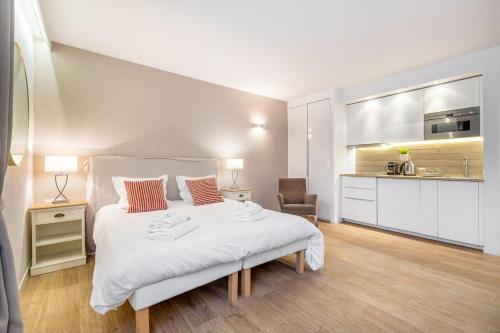 戛纳Agence des Résidences - Appartements privés du 45 CROISETTE - Superieur的一间带白色大床的卧室和一间厨房