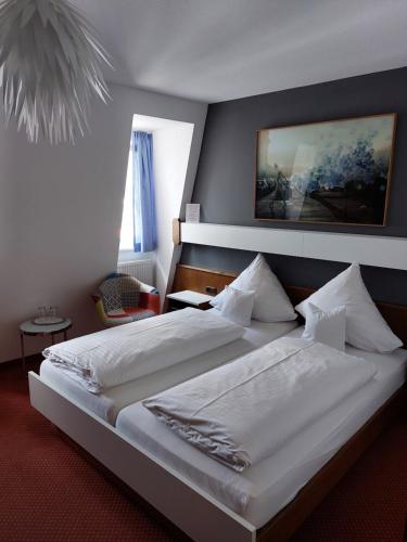 米尔滕贝格Hotel Garni "Brauerei Keller"的卧室配有一张带白色床单和枕头的大床。