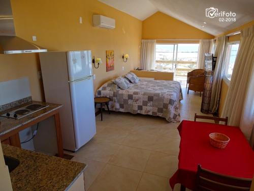 德尔迪阿布罗角阿酷乐啦酒店的厨房以及带一张床和冰箱的卧室