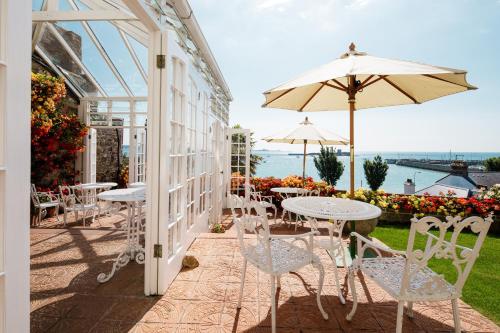 圣欧班潘拉玛旅馆的一个带桌椅和遮阳伞的庭院