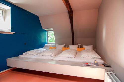 迪温特Hotel in het huis van Deventer的蓝色墙壁的房间里一张白色的床
