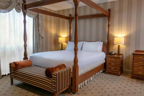 布里格Forest Pines Hotel, Spa & Golf Resort的一间卧室配有四柱床和长凳