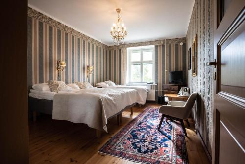 萨翁林纳Hotel Hospitz的一间卧室配有两张床和吊灯。