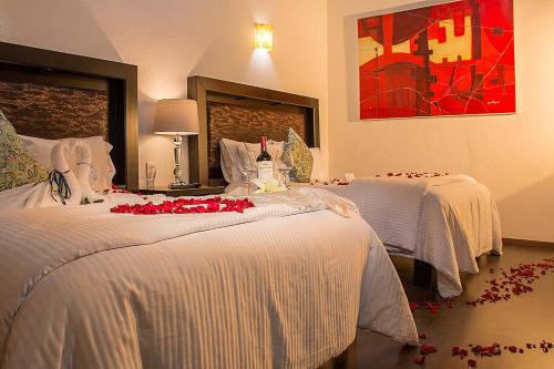 莫雷利亚M Hoteles Concepto的酒店客房设有两张红色玫瑰床。