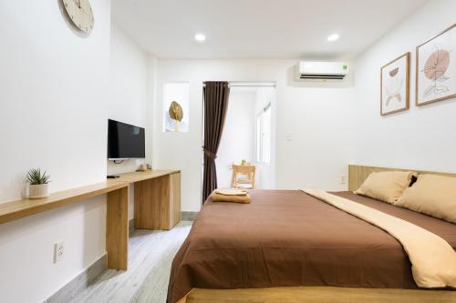 胡志明市Ekomo Home - Central Saigon的一间卧室配有一张床,墙上配有电视