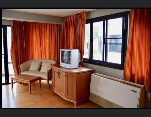 Ban Khlong Khotบ้านนาวาภิรมย์ ชะอํา的客厅配有沙发和橱柜上的电视