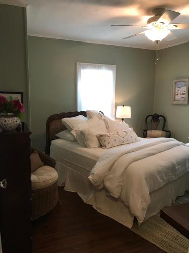 CutchogueSweet Dreams Bed and Breakfast Cutchogue的一间卧室配有一张带吊扇和窗户的床。