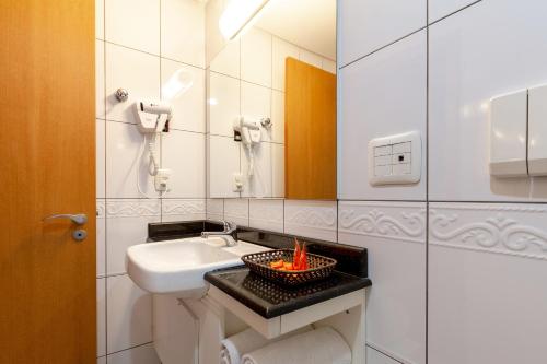 南卡希亚斯Tri Hotel Executive Caxias的一间带水槽和碗里的火炉的浴室