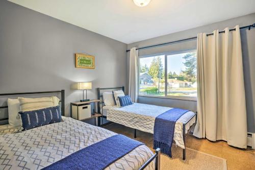 林伍德Lakefront Seattle Area House with Private Deck!的一间卧室设有两张床和大窗户