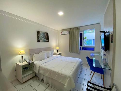 纳塔尔H Ponta Negra Beach的一间卧室配有一张床、一张书桌和一台电视