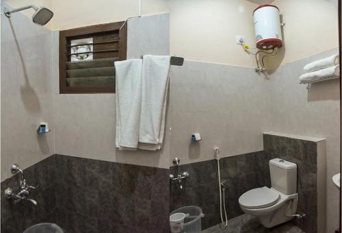 库姆巴科纳姆Kumbakonam Inn Hotels - Kumbakonam Inn Stay的一间带卫生间、淋浴和毛巾的浴室