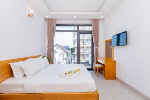 头顿Minh Phước Villa 12 Kim Ngân的一间卧室设有一张床、一台电视和一个窗口。