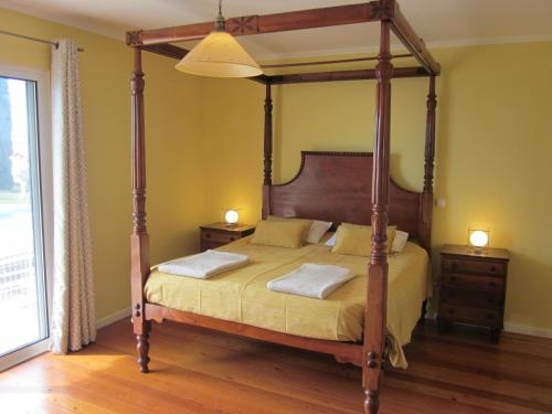 卡尼索Villa Hansen in Garajau - Cristo Rei的一间卧室配有一张带2个床头柜的四柱床