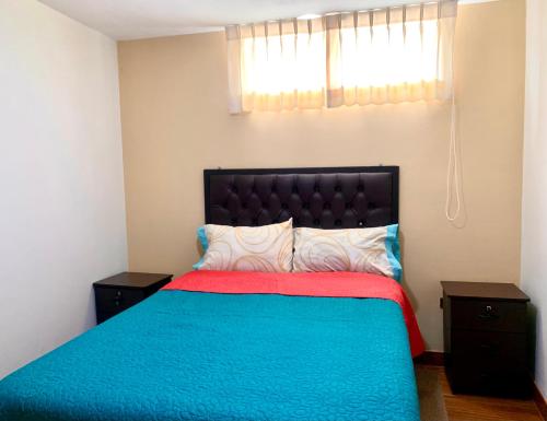 卡瓦纳科德Arum Qurpawasi Hospedaje的一间卧室配有一张带蓝色和红色毯子的床