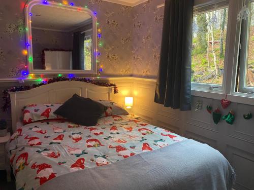 威廉堡Bluebell lodge的一间卧室配有一张带圣诞毯子和镜子的床