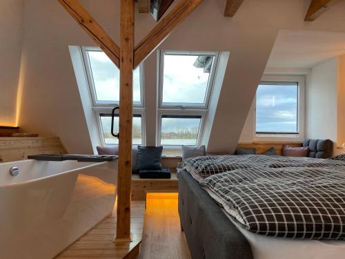 FünfhausenSonnenschein的一间卧室配有一张床、浴缸和窗户。