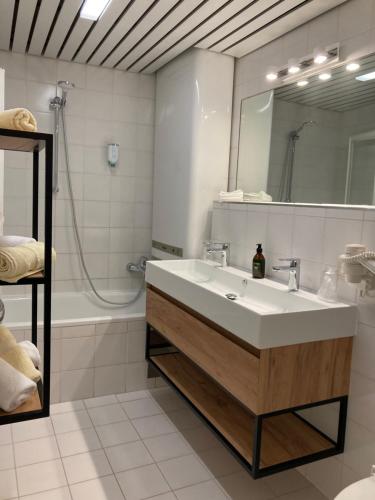 索尔登波斯塔尔斯公寓的浴室配有盥洗盆、镜子和浴缸
