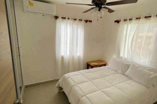 蓬塔卡纳Nice Apt in punta cana 7 minutes from airport , 10 minutes from the beaches的一间卧室配有一张床和吊扇