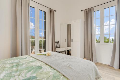 丰沙尔Casa D`Avó Celina的白色卧室设有床和大窗户