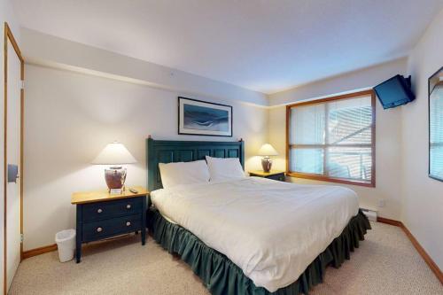 惠斯勒Aspens by WB Vacation Rentals的一间卧室设有一张大床和一个窗户。