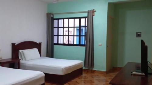 埃斯卡塞加casa YAAKUNAH的客房设有两张床、一个窗户和一张书桌。
