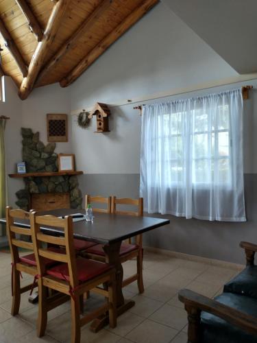 埃斯克尔Cabañas Pyracantha的一间带桌椅和窗户的用餐室