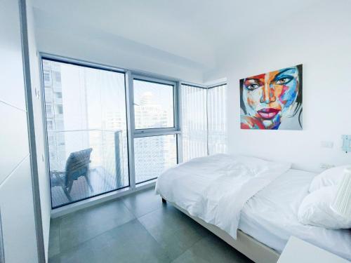 特拉维夫Midtown Tel Aviv Luxury Apartment的一间卧室设有一张床和一个大窗户