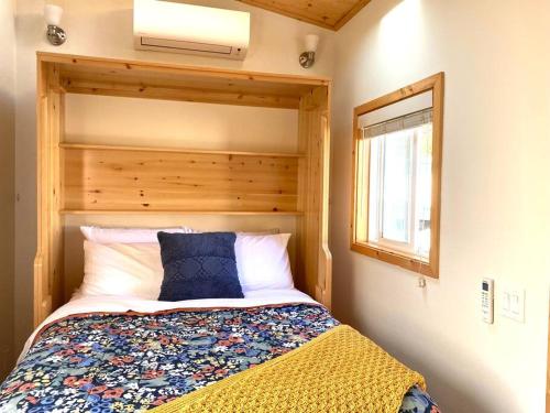 圣路易斯-奥比斯保Sunshine Tiny Home Near Downtown SLO的一间卧室配有一张带木制床头板的床和窗户。
