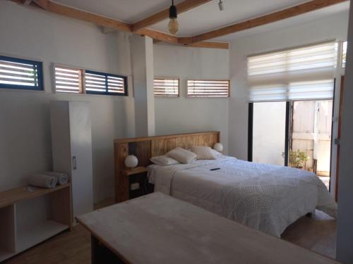 巴伊亚英格莱萨Hostal CKAIR的一间卧室配有一张带白色床单和窗户的床。