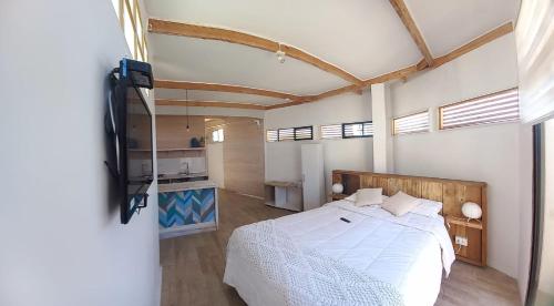巴伊亚英格莱萨Hostal CKAIR的一间带白色床的卧室和一间厨房