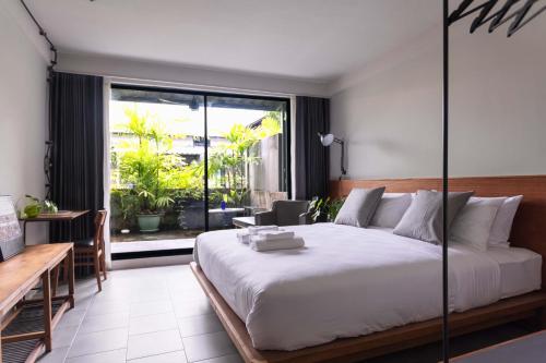 曼谷GalileOasis Boutique Hotel的一间卧室设有一张大床和一个大窗户