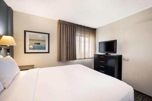伊姆派瑞尔Sonesta Simply Suites Pittsburgh Airport的配有一张床和一台平面电视的酒店客房