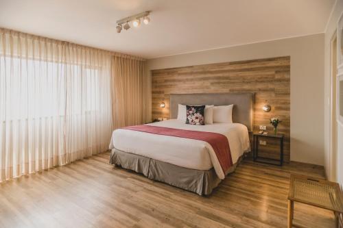 利马ARTE HOTEL Lima的一间卧室设有一张大床和木墙