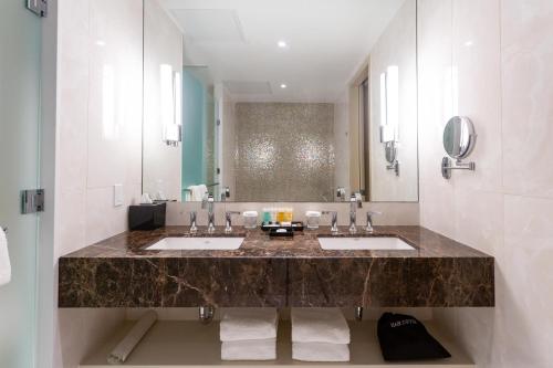 多伦多Sutton Place Hotel Toronto的大型浴室设有两个盥洗盆和大镜子