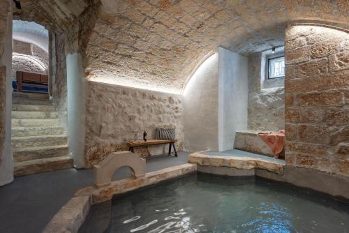 奥斯图尼Il Quinto Elemento - Residence Of Charme的大楼内带水池的房间