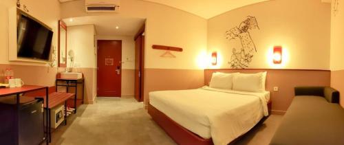 日惹Kotta GO Yogyakarta的配有一张床和一张书桌的酒店客房