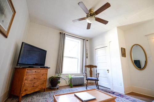 西沃德Brown & Hawkins Historical Apartments的客厅配有吊扇和电视。